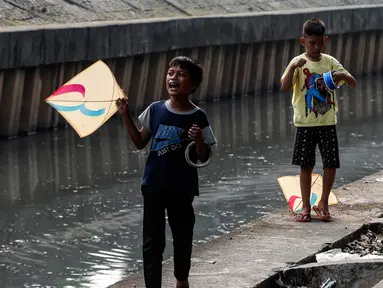 Anak-anak bermain layang-layang di pinggir kali Jalan Inspeksi Jakarta Barat, Rabu (12/7/2023). Meski berbahaya, mereka tetap menikmati bermain di pinggir kali tersebut. (Liputan6.com/Johan Tallo)