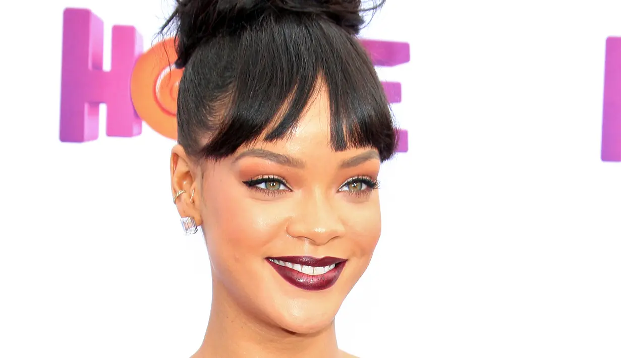 Pelantun 'Umbrella' ini membuktikan bahwa pemakaian lipstik warna merah gelap juga cocok untuk aktivitas di siang hari. (Bintang/EPA)