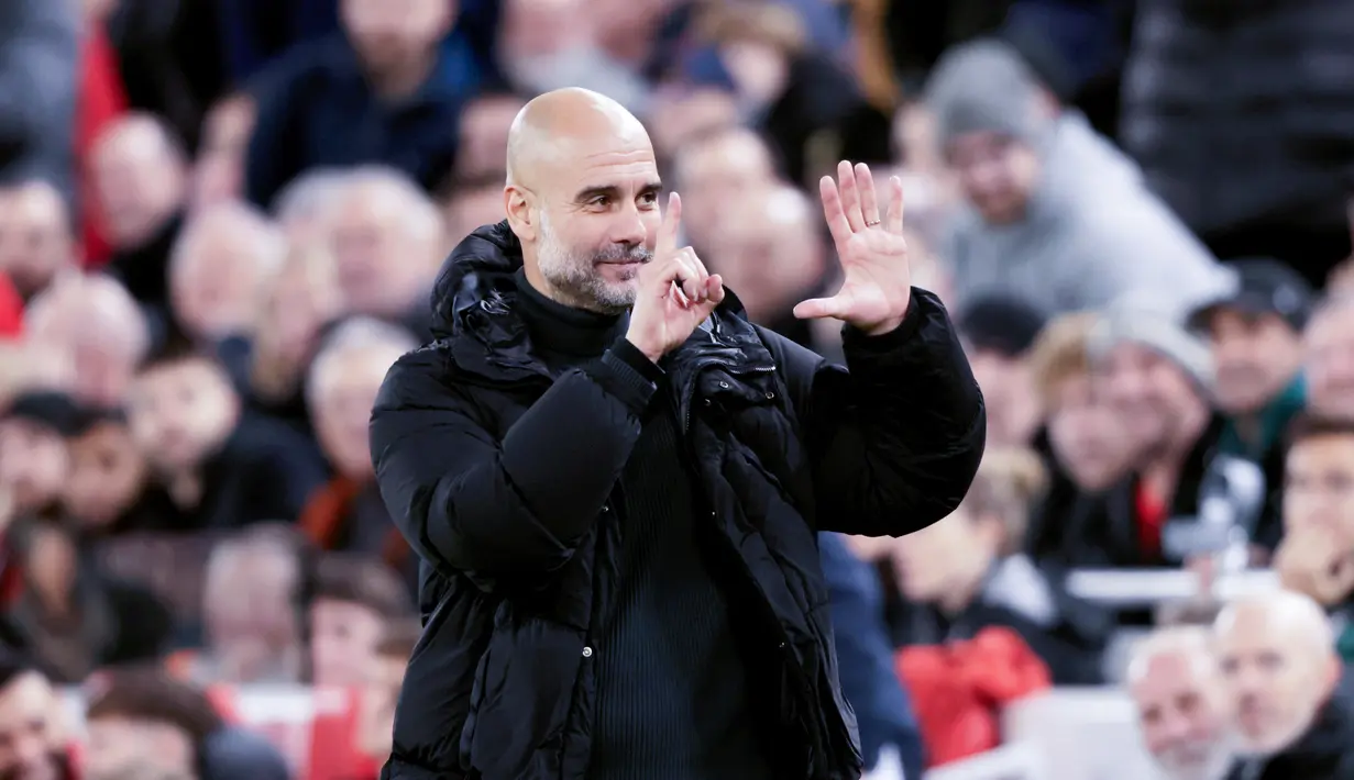 Mendengar nyanyian tersebut, Pep Guardiola langsung bereaksi dengan memberikan gestur angka enam ke arah penggemar Liverpool yang berada di tribun. (AP Photo/Ian Hodgson)