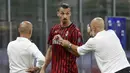 Pelatih AC Milan, Stefano Pioli, berusaha menenangkan Zlatan Ibrahimovic yang kecewa usai diganti saat melawan Bologna pada laga Serie A di Stadion San Siro, Sabtu (18/7/2020). AC Milan menang dengan 5-1 atas Bologna. (AP/Luca Bruno)