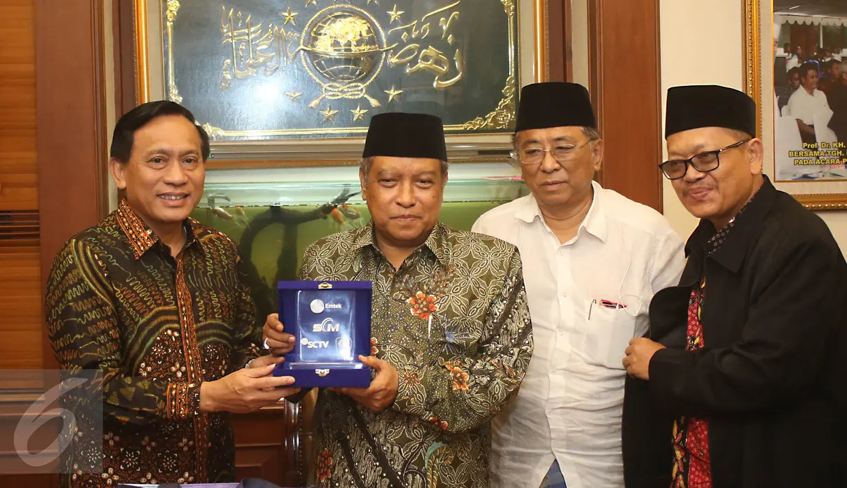Direktur Utama Indosiar Imam Sudjarwo memberikan cinderamata kepada Ketua Umum PBNU Said Aqil Siradj di kantor PBNU Jakarta, Senin (17/4). Pertemuan EMTEK Grup dengan PBNU dalam rangka silaturahmi. (Liputan6.com/Angga Yuniar)