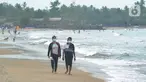 Wisatawan yang mengenakan masker menikmati suasana Pantai Anyer di Cilegon, Banten, Minggu (25/10/2020). Akhir pekan dimanfaatkan warga Jakarta dan sekitarnya untuk berwisata dengan tetap menerapkan protokol kesehatan Covid-19. (merdeka.com/Arie Basuki)