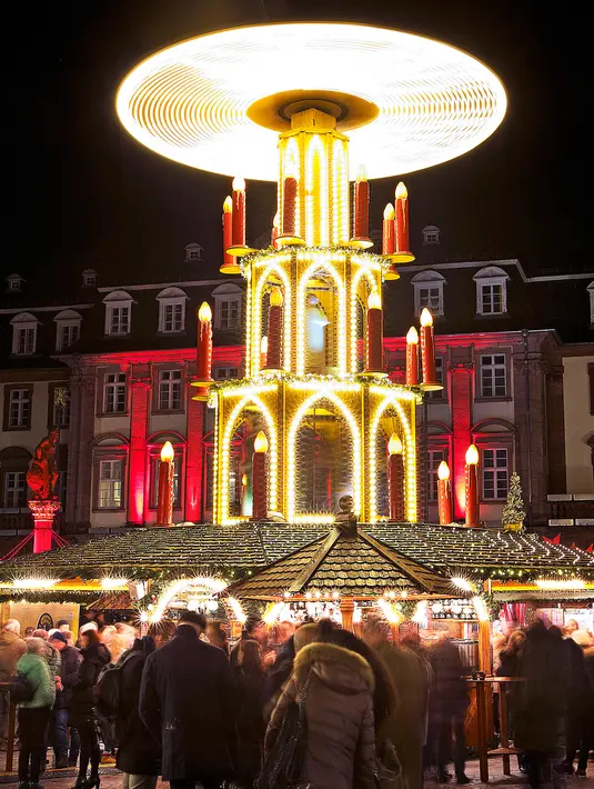 Pengunjung bermain komedi putar saat mengunjungi pasar Natal tradisional di Kota Tua Heidelberg, Jerman, Selasa (4/12). (AP Photo/Michael Probst)