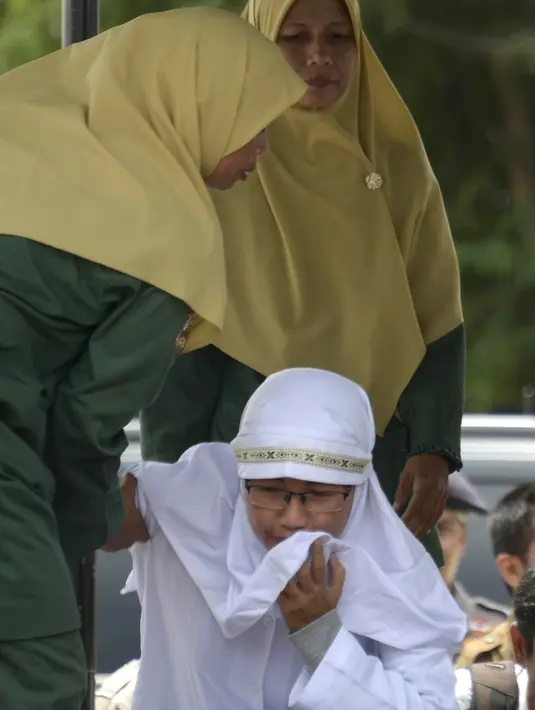 Ekspresi Tjia Nyuk Hwa saat menjalani hukum cambuk di luar Masjid Babussalam, Banda Aceh, Aceh, Indonesia, Selasa (27/2). Tjia Nyuk Hwa dan suaminya, Tjia Nyuk Hwa, memilih dicambuk meski mereka merupakan nonmuslim. (AFP FOTO/CHAIDEER MAHYUDDIN)