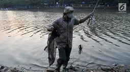 Warga memancing ikan di Danau Setu Babakan di Jagakarsa, Jakarta, Minggu (11/6). Memancing menjadi kegiatan warga sekitar Setu untuk mengisi waktu Ngabuburit. (Liputan6.com/Yoppy Renato)