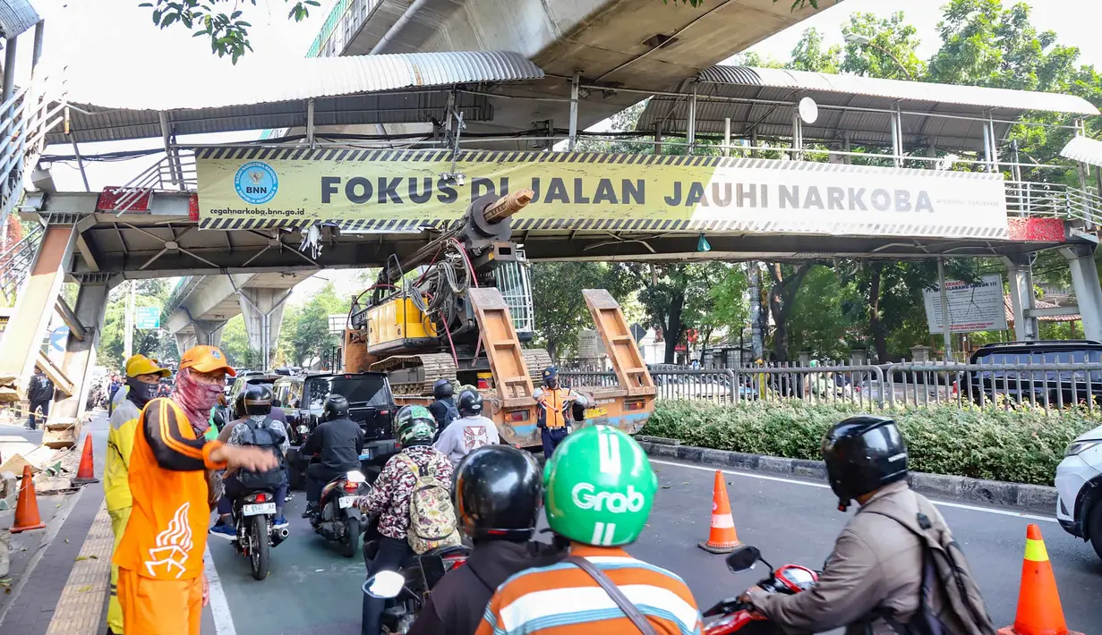 Sebuah truk  truk towing pengangkut alat berat (crane)  tersangkut dan merusak  jembatan penyeberangan orang (JPO) di Jalan Raya Kapten Tendean, Jakarta, Selasa (14/07/2026).