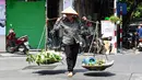 Ribuan pedagang kaki lima, sebagian besar perempuan, di ibu kota Vietnam tidak punya pilihan selain bekerja melewati serangkaian gelombang panas yang melanda bagian utara negara tersebut dalam beberapa minggu terakhir. (Photo by Nhac NGUYEN / AFP)