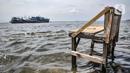 Sebuah bangku saat terendam banjir rob di Pelabuhan Kali Adem, Muara Angke, Jakarta, Kamis (22/10/2020). Banjir akibat air pasang dengan ketinggian mencapai 30 cm tersebut telah merendam kawasan Pelabuhan Kali Adem dan sudah berlangsung selama lima hari. (merdeka.com/Iqbal S. Nugroho)