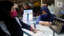 Pegawai BSI Cabang Mayestik memberikan penjelasan fitur gadai dan cicil emas di salah satu kios saat Grebek Pasar BSI di Pasar Mayestik, Jakarta (16/12/2021). Grebek pasar ini dalam rangka memperluas informasi dan awareness dan menjaring calon nasabah baru di 23 titik pasar. (Liputan6.com/HO/Rizky)