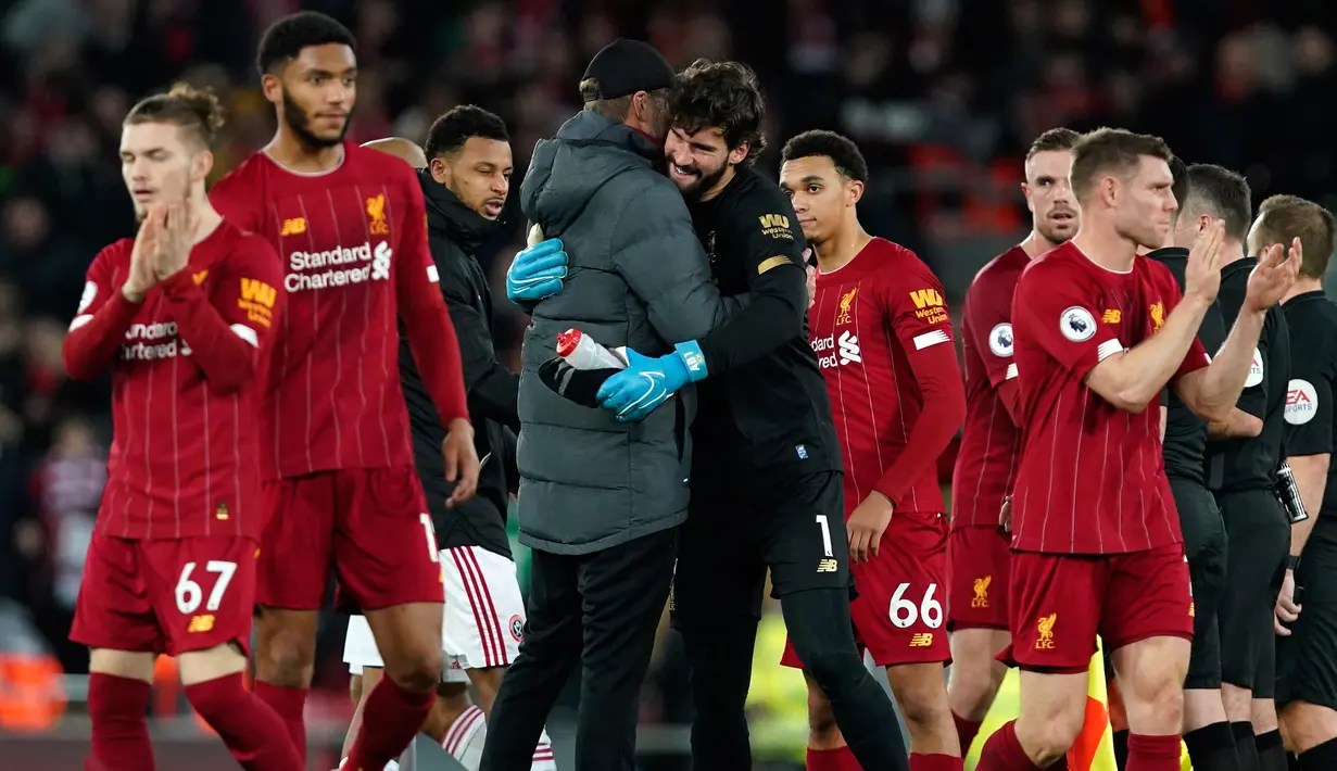 Manajer Liverpool Jurgen Klopp (kiri tengah) merangkul penjaga gawang Alisson pada akhir laga Liga Inggris antara Liverpool dengan Sheffield United di Anfield Stadium, Liverpool, Inggris, Kamis (2/1/2020). Liverpool menang 2-0. (AP Photo/Jon Super)