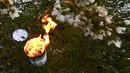 Lilin antiembun beku menyala untuk melindungi pohon dari embun beku di sebuah kebun karena suhu diperkirakan akan turun di bawah nol derajat celcius dalam beberapa hari ke depan di Westhoffen, Prancis, 6 April 2021. (Frederick FLORIN/AFP)