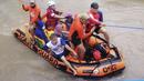 Warga menaiki perahu karet di sepanjang banjir yang disebabkan oleh Topan Rai saat mereka dievakuasi ke tempat yang lebih tinggi di Cagayan de Oro City, Filipina selatan, Kamis (16/12/2021). (Philippine Coast Guard via AP)
