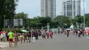 Sejumlah pengunjung berjalan saat sedang liburan di Monumen Nasional (monas), Jakarta, Selasa (25/12). Liburan Natal 2018, banyak warga datang bersama kerabat maupun keluarga memadati Monas. (Liputan6.com/Herman Zakharia)