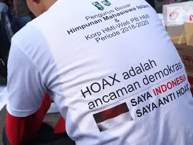 Salah satu pengurus PB HMI melihat warga yang menandatangani spanduk dukungan anti hoax di kawasan Bundaran Hotel Indonesia, Jakarta, Minggu (18/11). PB HMI mensosialisasikan Hoax sebagai ancaman demokrasi di Indonesia. (Liputan6.com/Helmi Fithriansyah)