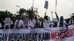 Massa dari Pergerakan Dokter Muda Indonesia melakukan aksi di depan Istana Negara, Jakarta, Kamis (19/7). Mereka ingin mengadukan isu terkait pungli yang dilakukan Fakultas Kedokteran dan Kemenristek Dikti Ke Presiden Jokowi. (Liputan6.com/Johan Tallo)
