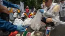 Para peserta menyortir sampah yang mereka pungut saat mengambil bagian dalam tahap Jepang "SpoGOMI World Cup 2023" di mana para tim memungut sampah sebanyak mungkin, di daerah Shinjuku, Tokyo pada tanggal 9 Oktober 2023. (Richard A. Brooks/AFP)