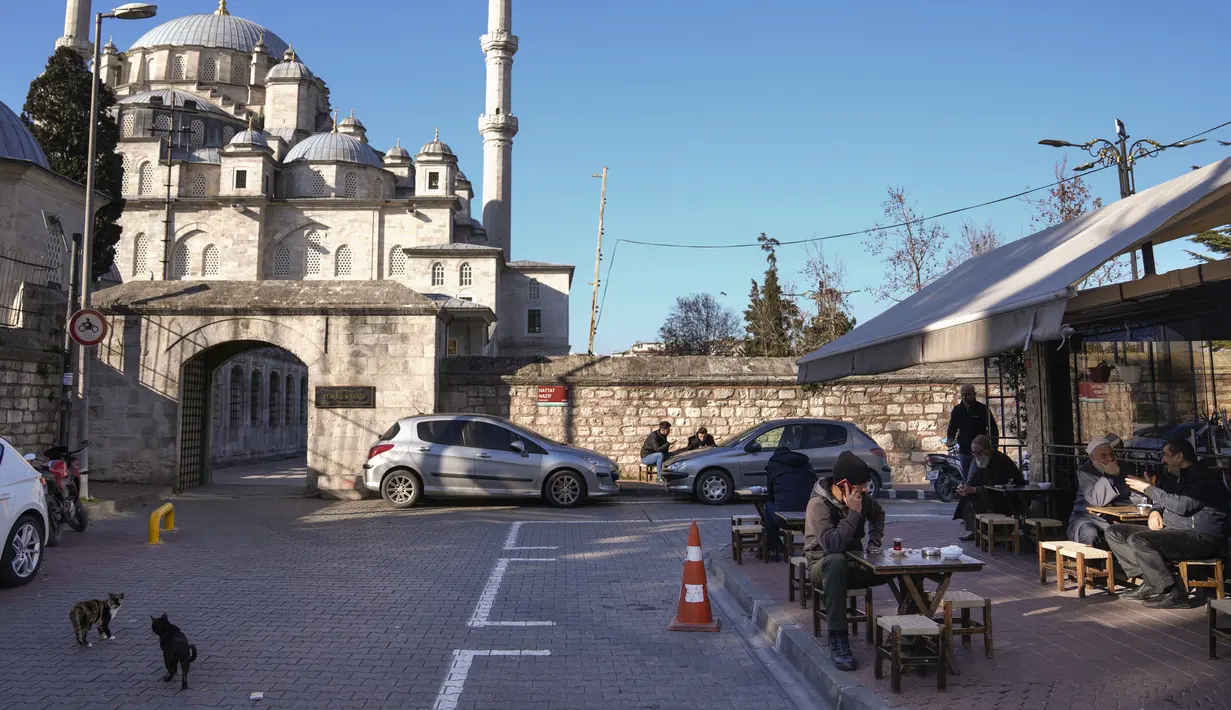 <p>Orang-orang duduk di teras sebuah kedai kopi di sebelah masjid Fatih di Istanbul, Turki, Selasa, 3 Januari 2023. Ini merupakan bulan kedua secara berturut-turut, inflasi Turki mereda sejak merasakan rekor inflasi tertinggi selama 84 tahun sebesar 85,5 persen (yoy) pada Oktober 2022. (AP Photo/Khalil Hamra)</p>