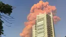 Sebuah foto yang diambil dari Teluk Zaytouna menunjukkan gumpalan api merah di belakang sebuah bangunan tinggi di pusat kota Beirut tepat setelah ledakan besar mengguncang ibukota Lebanon (4/8/2020). (AFP Photo/Bassem El Hage)