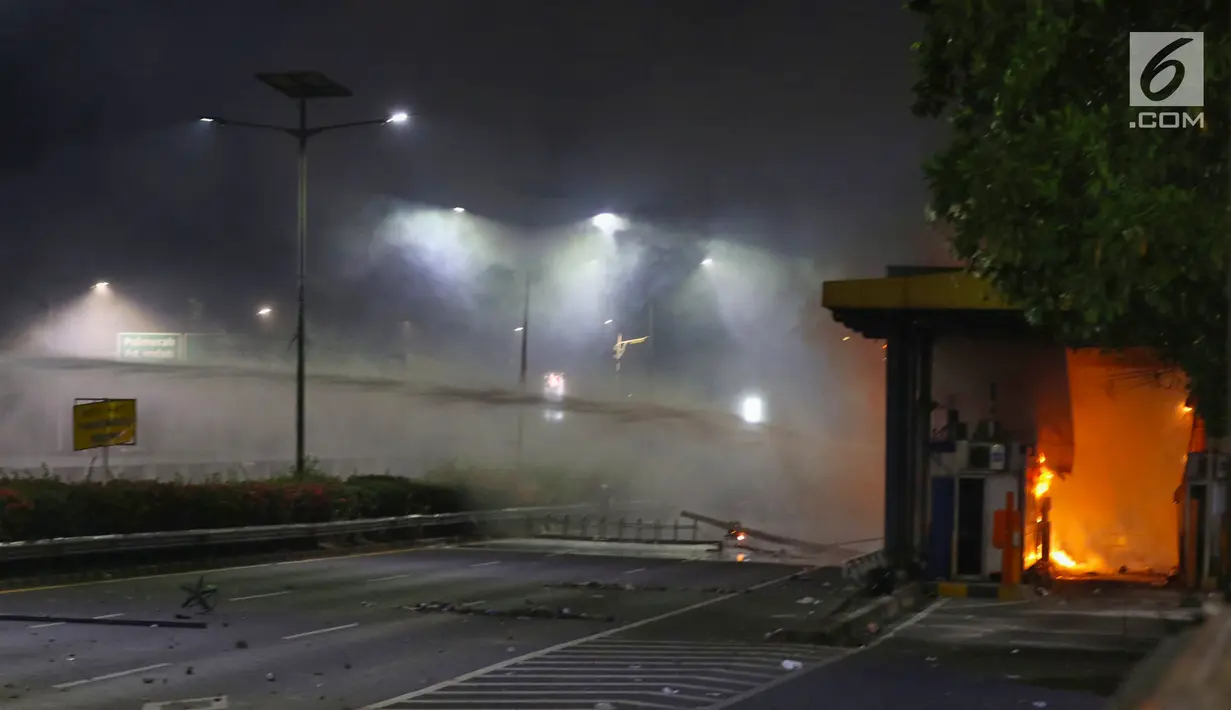 Gardu Tol Pejompongan 1 dibakar massa saat demonstrasi mahasiswa di depan Gedung DPR/MPR, Jakarta, Selasa (24/9/2019). Demonstrasi mahasiswa berujung ricuh, polisi menembakkan gas air mata dan water cannon untuk membubarkan demo. (Liputan6.com/Johan Tallo)