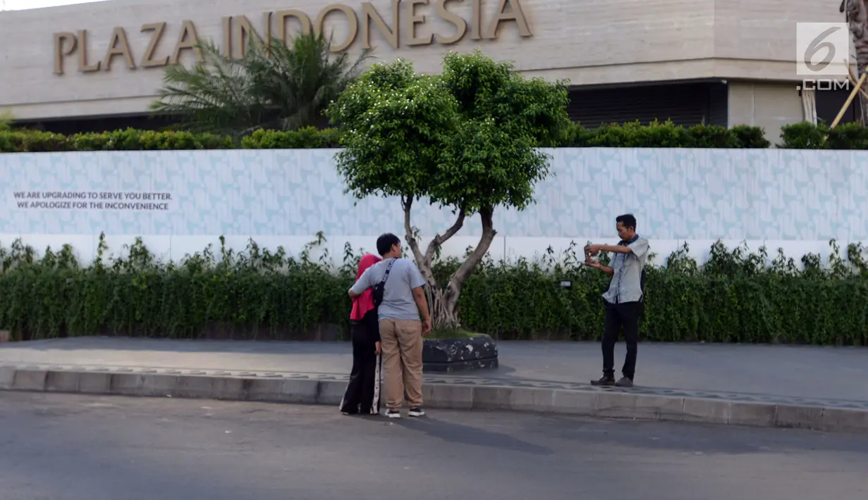 Warga berfoto di Jalan MH Thamrin, Jakarta Pusat, Jumat (24/5/2019). Dari pantauan lapangan, kondisi sekitar jalan protokol tersebut kondusif dan tidak tampak tanda-tanda unjuk rasa lanjutan usai Aksi 22 Mei 2019. (merdeka.com/Imam Buhori)
