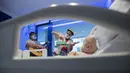 Badut dari LSM Media Sunrise (Senyuman Medis) tampil untuk bayi di sayap anak-anak Rumah Sakit Son Espases, Palma de Mallorca, Spanyol, 8 Maret 2021. (JAIME REINA/AFP)