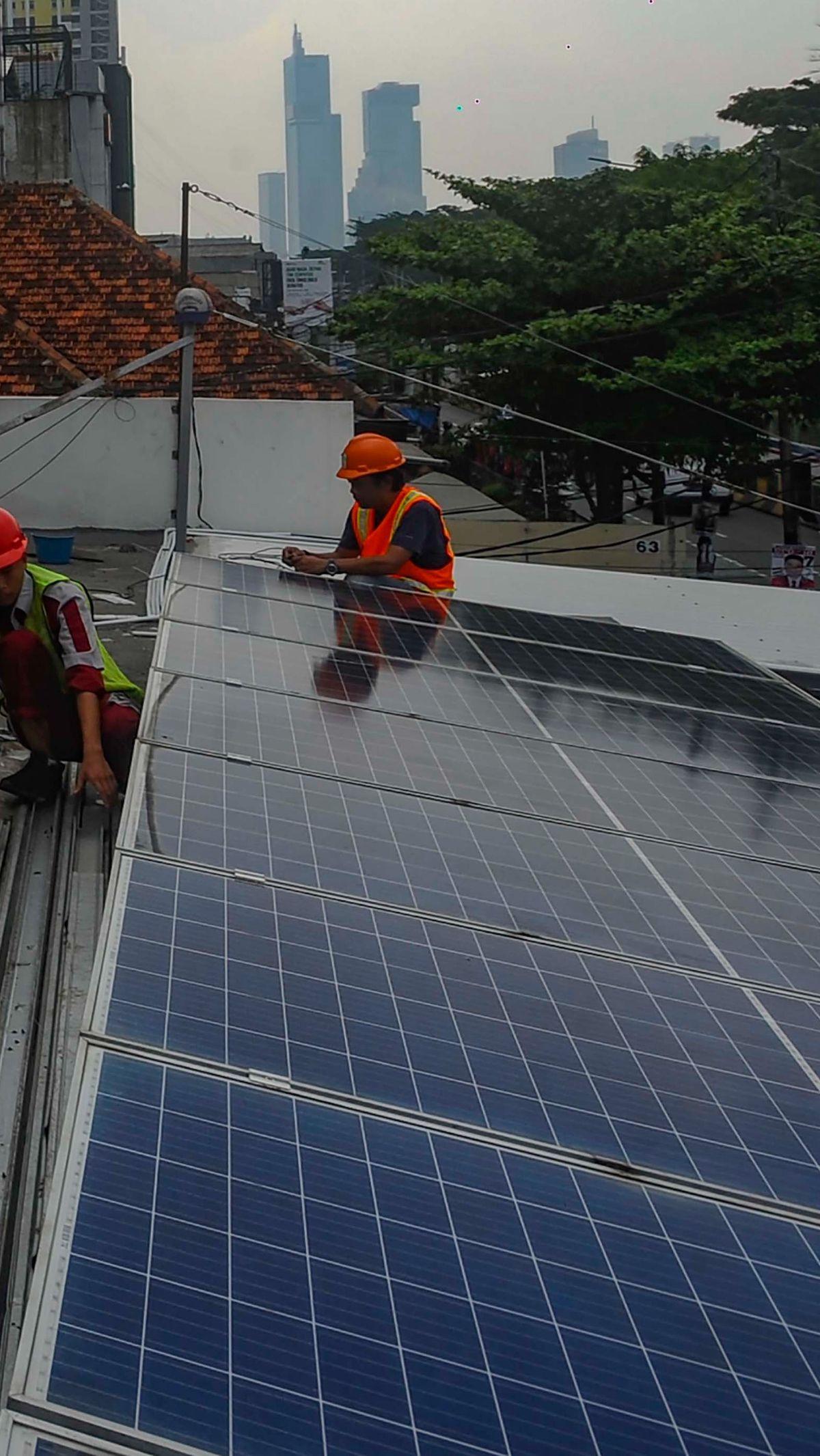 Teknisi Green Energy Nusantara Mandiri memasang panel surya untuk Pembangkit Listrik Tenaga Surya (PLTS) Hybrid 6210 Wp battery 4,8 kwh pada atap sebuah rumah di kawasan Manggarai, Jakarta, Jumat (29/12/2023). PLTS saat ini menjadi alternatif energi ramah