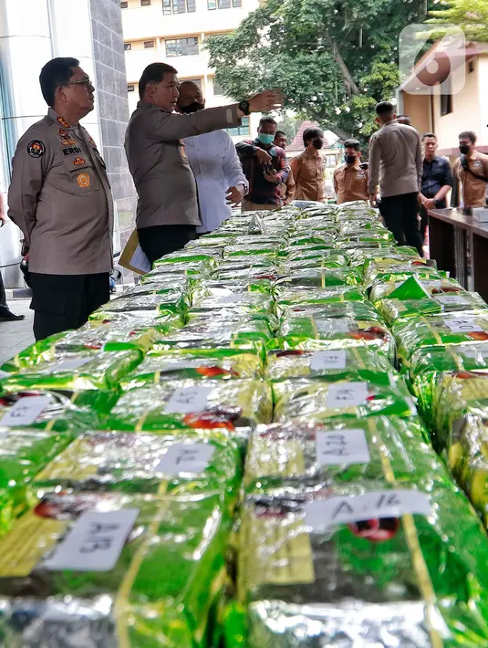 Direktur Tindak Pidana Narkoba Bareskrim Polri Brigjen Pol Krisno Halomoan Siregar (kemeja putih) memeriksa barang bukti sabu dan  ekstasi di Mabes Polri, Jakarta, Rabu (22/2/2023). Adapun total barang bukti sitaan 220 kilogram sabu dan 705 butir ekstasi dengan tujuh tersangka. (Liputan6.com/Angga Yuniar)