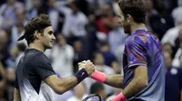 Roger Federer memberikan ucapan selamat kepada Juan Martin del Potro usai laga perempat final AS Terbuka 2017 di Arthur Ashe Stadium, New York,(6/9/2017). Federer kalah 5-7, 6-3, 6-7, 4-6.  (AP/Julio Cortez)