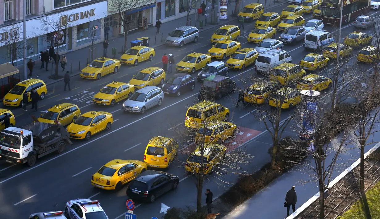 Taksi memblokir jalan utama di pusat kota Budapest, Hongaria, (18/1). Pengemudi taksi konvensional memprotes taksi online Uber yang beroperasi d Hongaria. (REUTERS / Laszlo Balogh)