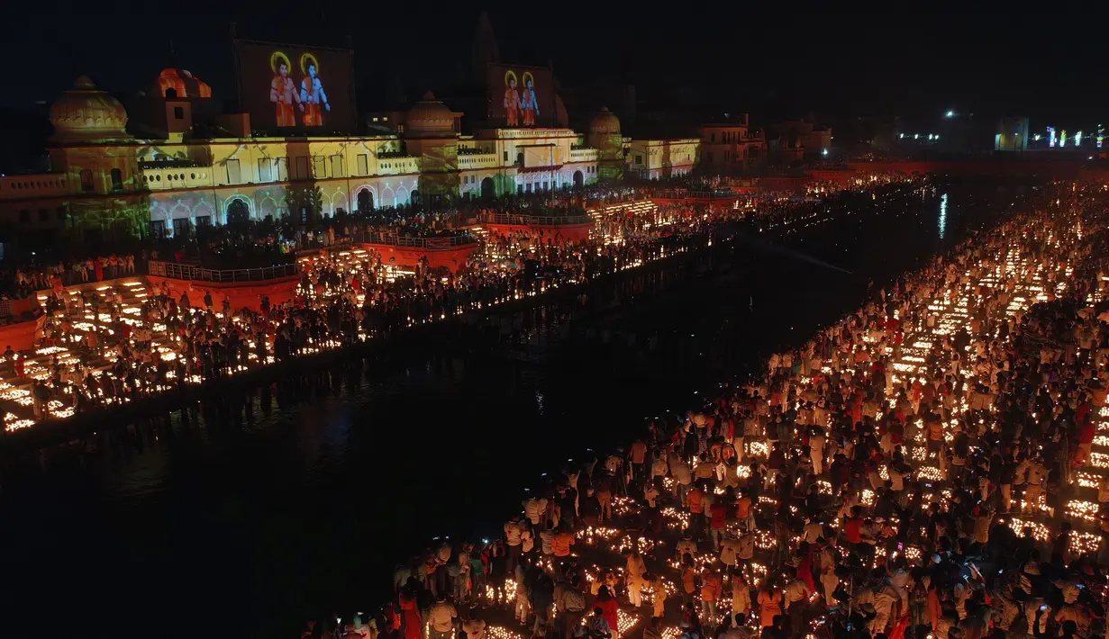 Orang-orang menyalakan lampu di tepi sungai Saryu di Ayodhya, India, Rabu (3/11/2021). Lebih dari 900.000 lampu minyak dinyalakan dan terus menyala selama 45 menit saat kota Ayodhya mempertahankan Rekor Dunia Guinness sebagai bagian dari perayaan festival Diwali. (AP Photo/Rajesh Kumar Singh)