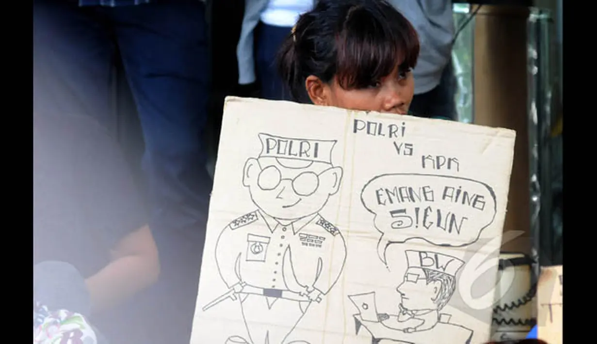 Seorang aktivis menggelar spanduk berisi dukungan kepada KPK di gedung Komisi Pemberantas Korupsi, Jakarta, Sabtu (24/1/2014). (Liputan6.com/Herman Zakharia)