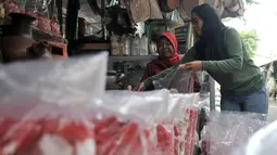 Pedagang melayani pembeli di salah satu kios kembang makam di Pasar Rawa Belong, Jakarta, Senin (29/4). Pasar Rawa Belong merupakan pusat grosir aneka kembang makam yang diburu oleh para pedagang kembang makam di Ibu Kota. (merdeka.com/Iqbal Nugroho)