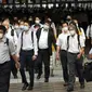 Komuter yang mengenakan masker berjalan di lorong selama jam sibuk di Stasiun Shinagawa, Tokyo, Senin (12/7/2021). Otoritas Jepang menempatkan Tokyo di bawah keadaan darurat Covid-19 keempat sebagai upaya menahan lonjakan kasus infeksi virus Corona dari Senin hingga 22 Agustus. (AP /Eugene Hoshiko)