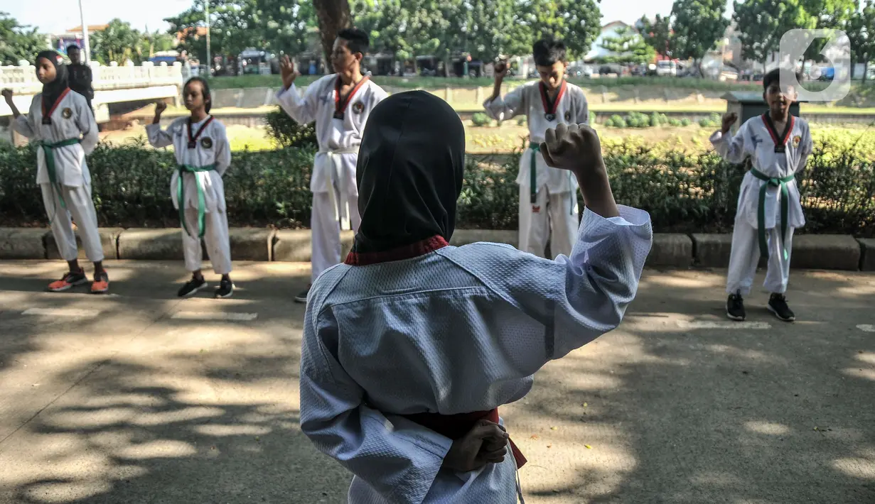 Murid Taekwondo Indonesia Manroe Club mengucapkan Janji Taekwondo sebelum mengikuti latihan rutin di kawasan Kanal Banjir Timur (KBT), Jakarta Timur, Senin (16/8/2021). Protokol kesehatan dilakukan terhadap murid maupun orangtua yang mengantarkan anak mereka. (merdeka.com/Iqbal S. Nugroho)