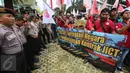 Polisi berjaga saat Serikat Pekerja JICT menggelar aksi unjuk rasa di depan Gedung KPK, Jakarta, Selasa (9/5). Pekerja mendorong KPK untuk mengusut kasus korupsi dengan tersangka R.J Lino yang diduga melibatkan pejabat negara. (Liputan6.com/Helmi Afandi)
