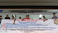 Petugas memasang spanduk sosialisasi peningkatan kesadaran untuk menghormati hasil karya intelektual di salah satu pusat perbelanjaan elektronik di Mangga Dua, Jakarta, Rabu (18/5).(Liputan6.com/Immanuel Antonius)