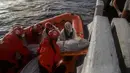 Petugas LSM Spanyol mengevakuasi mayat imigran Afrika sub-Sahara di tengah Laut Mediterania, lepas pantai Libya, Selasa (25/7). Petugas menemukan 13 mayat, termasuk ibu hamil dan anak-anak, di atas perahu karet yang membawa 160 migran. (AP/Santi Palacios)