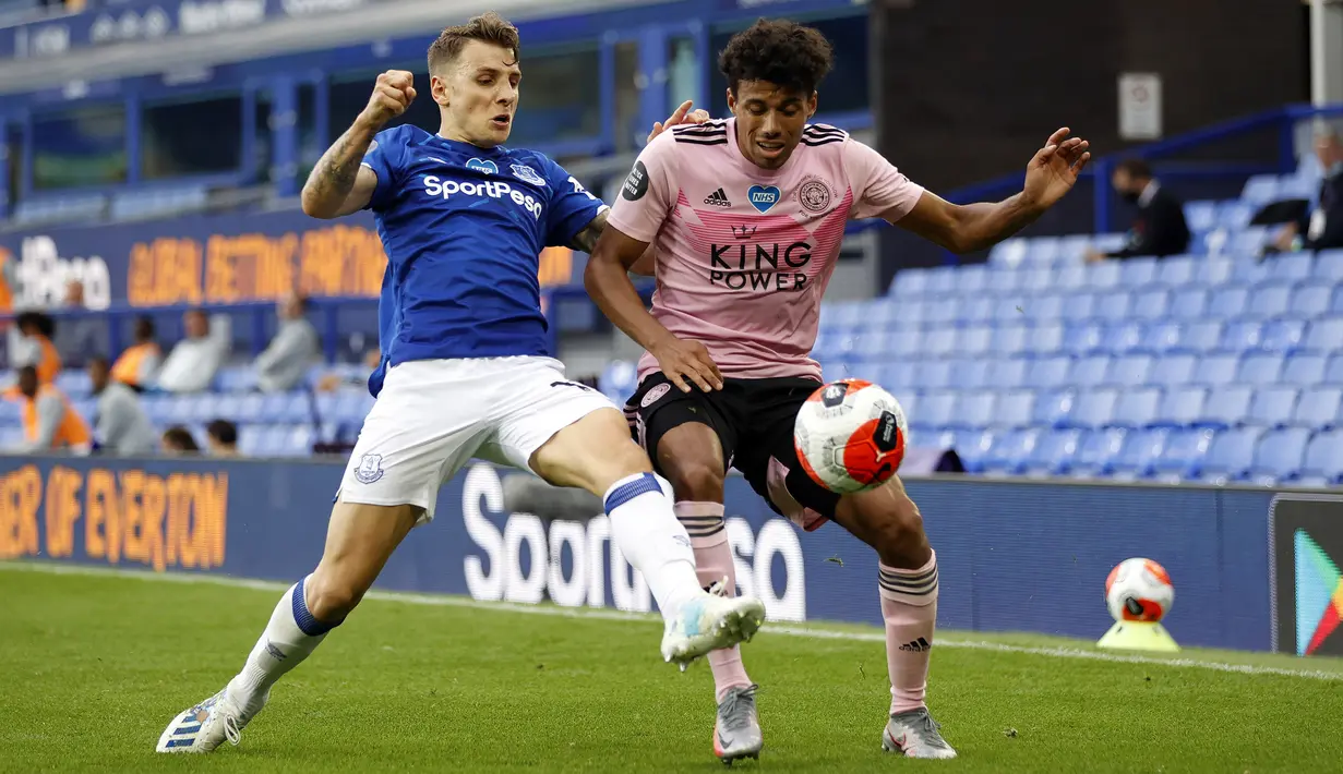 Bek Leicester City, James Justin, berebut bola dengan bek Everton, Lucas Digne, pada laga Premier League pekan ke-32 di Goodison Park, Kamis (2/7/2020) dini hari WIB. Leicester City kalah 1-2 atas Everton. (AFP/Clive Brunskil/pool)