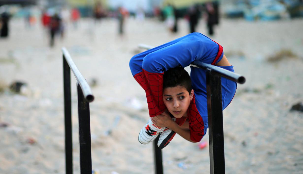 Mohammed al Sheikh menunjukkan kemampuannya di sebuah pantai di Kota Gaza, Palestina, Kamis (2/6). Dengan tinggi 1,6 meter dan berat 29 kg, Mohammed mampu menekukan tubuhnya dengan posisi yang menurut kita mustahil untuk dilakukan (REUTERS/Mohammed Salem)