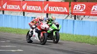 Pebalap Astra Honda Racing Team, Gerry Salim (31), bersaing ketat dengan pebalap Kawasaki, Ahmad Yudhistira, pada balapan pertama Kejurnas Supersport 600cc di Sirkuit Sentul, Bogor, Minggu (22/5/2016). (Astra Honda Racing Team)