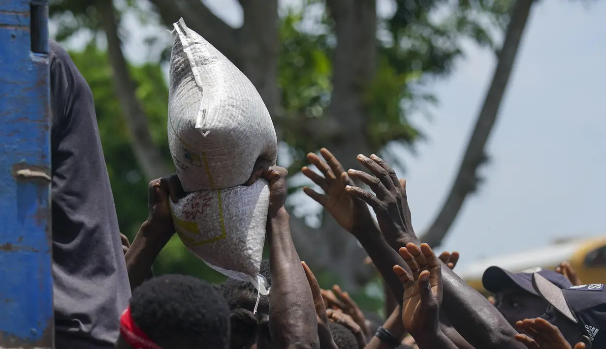 Warga berebut sekantong beras yang disumbangkan di dekat sebuah truk yang penuh dengan persediaan bantuan di Vye Terre, Haiti, Jumat (20/8/2021).  Bantuan swasta dan kiriman dari pemerintah AS dan lainnya tiba di semenanjung barat daya negara itu. dilanda. (AP Photo/Fernando Llano)