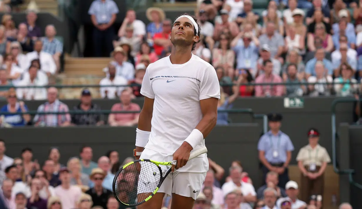 Petenis Spanyol, Rafael Nadal menengadahkan kepalanya saat melawan petenis asal Luksemburg, Giller Muller pada perempat final Wimbledon 2017 di London, Senin (10/7). Nadal akhirnya kalah dengan skor akhir 3-6, 4-6, 6-3, 6-4, 13-15. (AP/Tim Ireland)
