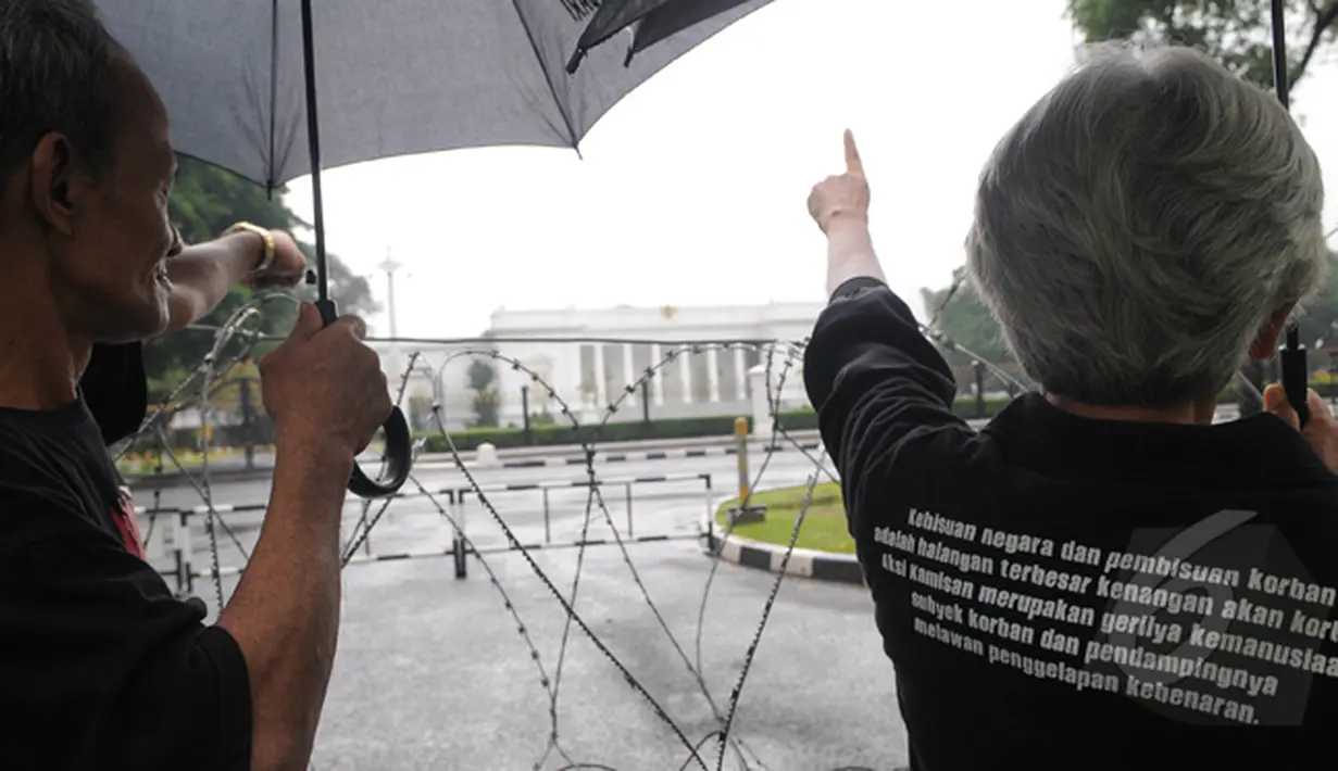 Keluarga korban pelanggaran HAM menunjuk Istana Negara saat 'Aksi Diam Kamisan'. Aksi ini telah memasuki tahun ke delapan, Jakarta, Kamis (22/1/2105). (Liputan6.com/Herman Zakharia)