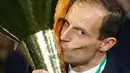 Pelatih Juventus, Massimiliano Allegri mencium Piala Liga Italia Serie A usai menjuarainya untuk ke-33 kalinya di Stadion Allianz, Turin (19/5/2019). Juventus meraih gelar scudetto kedelapan secara beruntun sekaligus rekor baru. (AP Photo/Antonio Calanni)