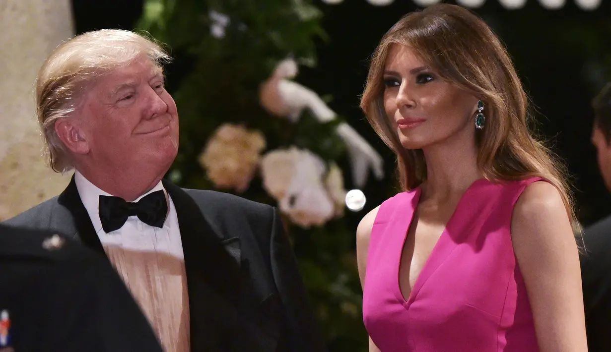Ekpresi Melania Trump saat mendampingi Donald Trump menghadiri gala tahunan Palang Merah Amerika ke-60 di Mar-a-Lago, Florida, AS (4/2). (AFP/Mandel Ngan)