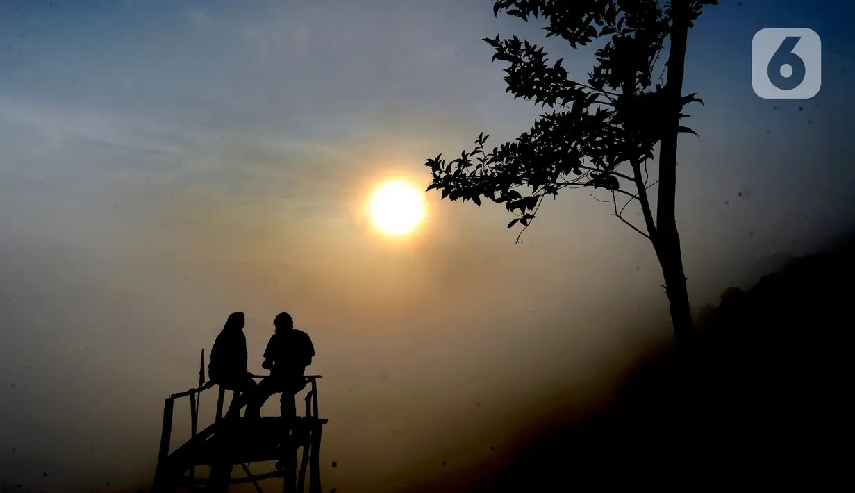 Pengunjung menunggu hilangnya kabut yang menutupi kawasan Gunung Luhur di Desa Citorek Kidul, Kecamatan Cibeber, Kabupaten Lebak, Banten, Sabtu (23/11/2019). Wisata “Negeri Di Atas Awan” yang sempat tutup sementara sejak September 2019 lalu ini kembali ramai oleh wisawatan. (merdeka.com/Arie Basuki)