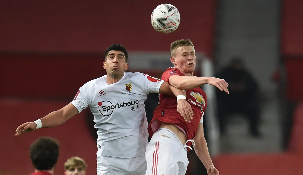 Bek Watford, Adam Masina (kiri) berduel udara dengan gelandang Manchester United, Scott McTominay dalam laga babak ke-3 Piala FA 2020/21 di Old Trafford, Sabtu (9/1/2021). Watford kalah 0-1 dari Manchester United. (AFP/Oli Scarff/Pool)