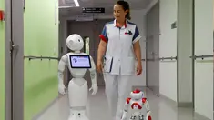 Seorang perawat berjalan bersama robot humanoid bernama Pepper (kiri) dan Zora di rumah sakit AZ Damiaan ,Ostend , Belgia, (16/6). Robot ini dirancang atau dibuat untuk mengurus pasien yang datang ke rumah sakit. (REUTERS / Francois Lenoir)