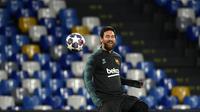 Penyerang Barcelona, Lionel Messi mengontrol bola saat mengikuti saat sesi latihan tim di stadion San Paolo di Naples, Italia (24/2/2020). Barcelona akan bertanding melawan Napoli pada leg pertama babak 16 besar Liga Champions. (AFP/Filippo Monteforte)