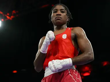 Reaksi petinju kontingen pengungsi, Cindy Ngamba setelah mengalahkan petinju Prancis Davina Michel pada perempat final kelas 75kg putri Olimpiade Paris 2024 di North Paris Arena, Minggu (4/8/2024). (MOHD RASFAN / AFP)